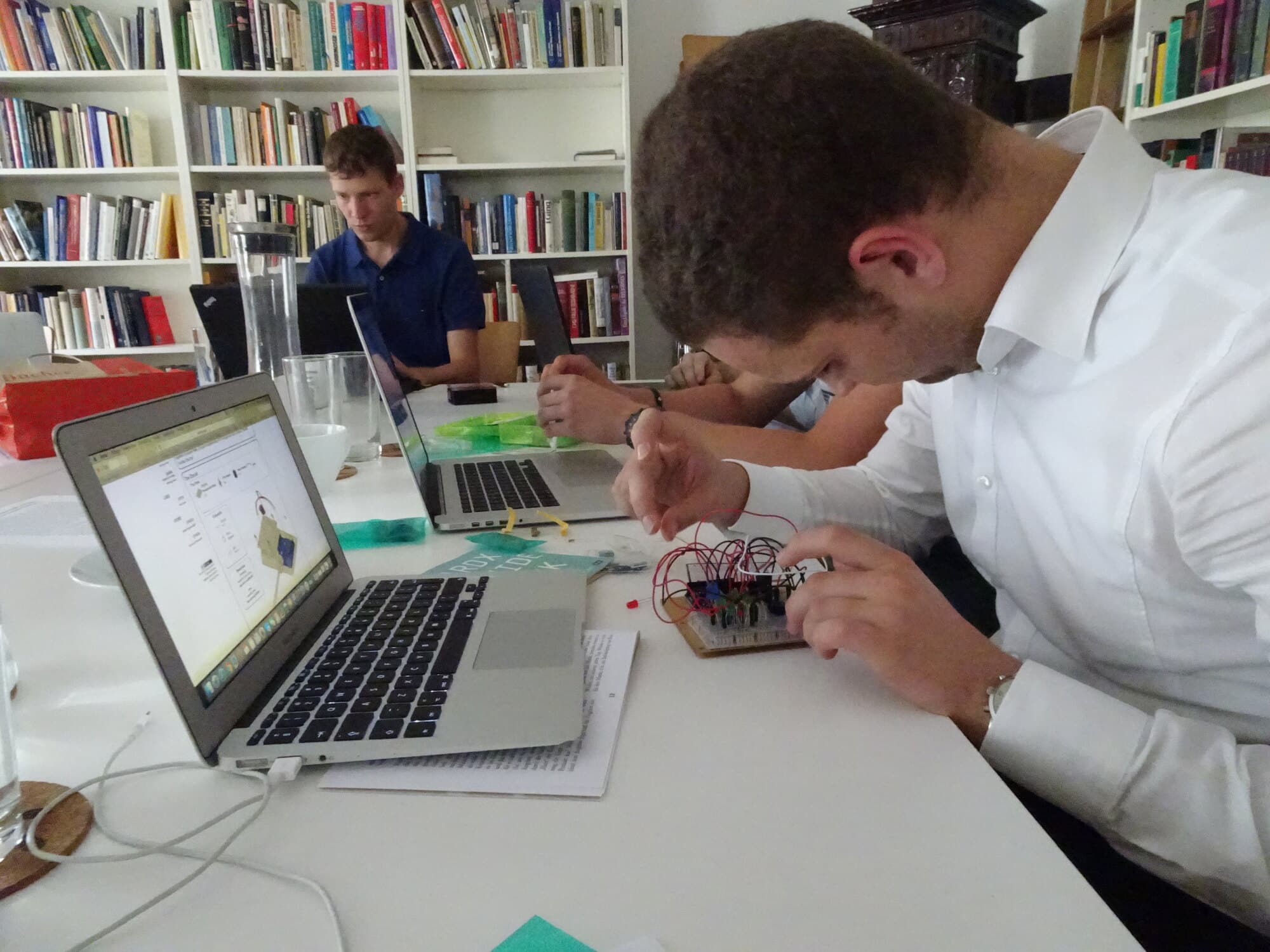 Ein CRAFTprobe-Teilnehmer verbindet Drähte auf einem Elektronik-Prototyp neben seinem Laptop