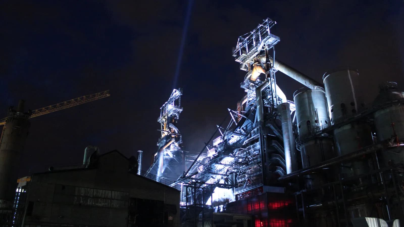 Los altos hornos iluminados de Esch-Belval contra el cielo nocturno.