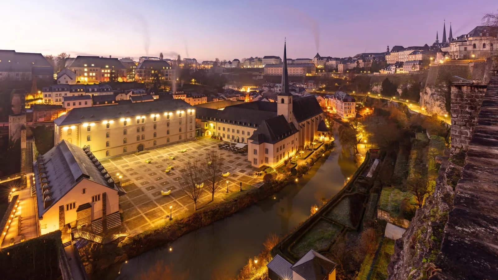 La abadía de Neumünster y el barrio del Grund al atardecer, dominados por las rocas y murallas de la fortaleza del Bock.