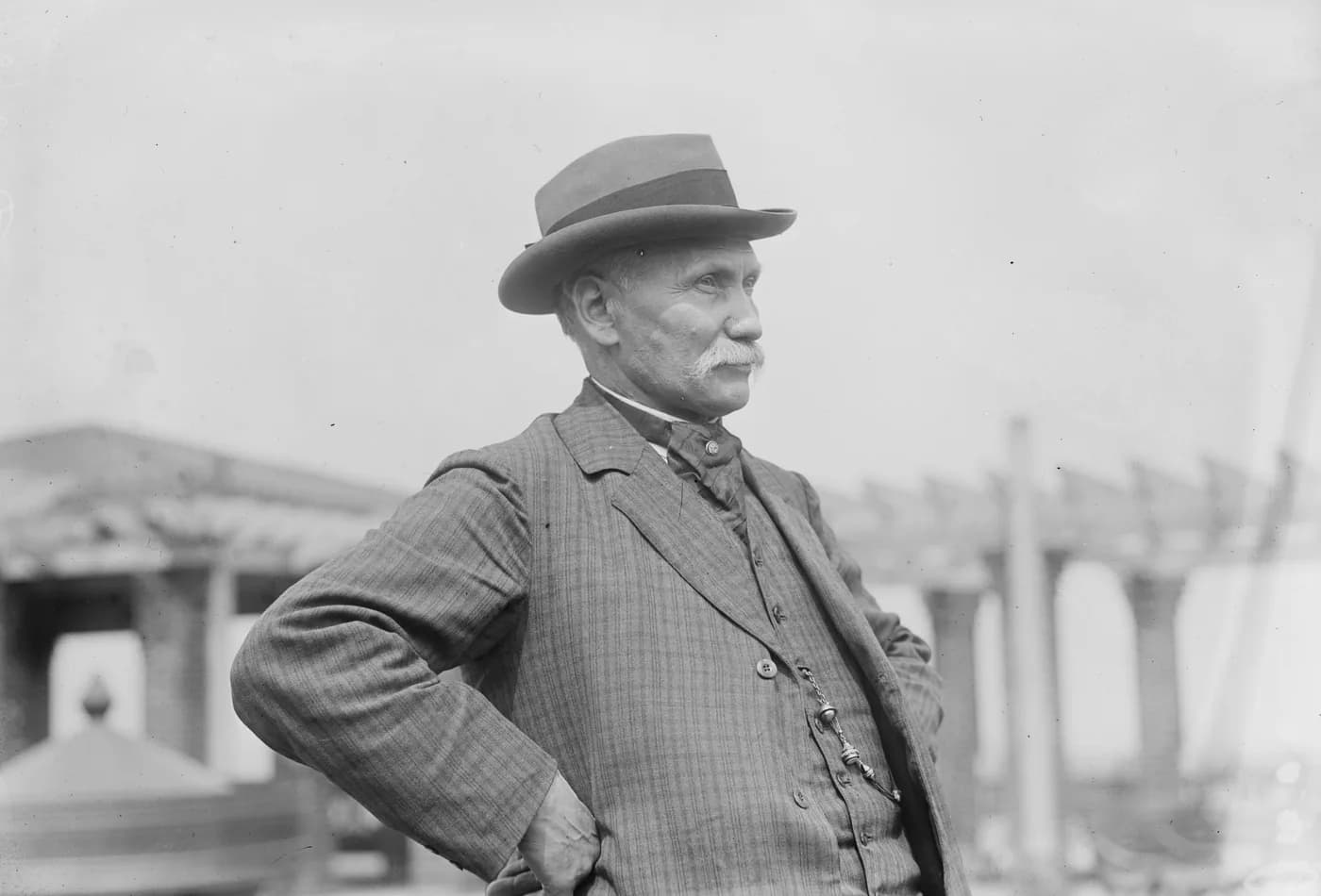 Wilhelm Voigt, the Captain of Köpenick, in a striped suit and hat, hands on his hips.